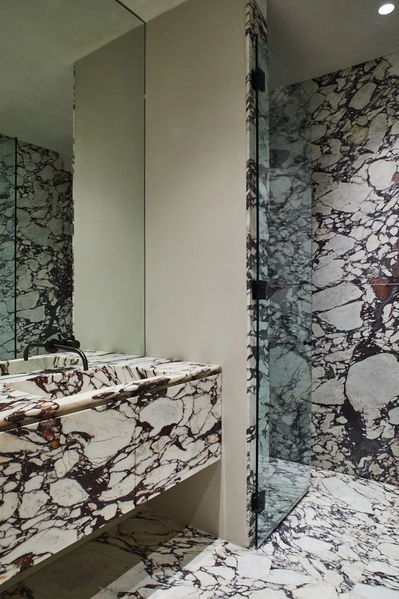 Bold marble used across vanity and shower